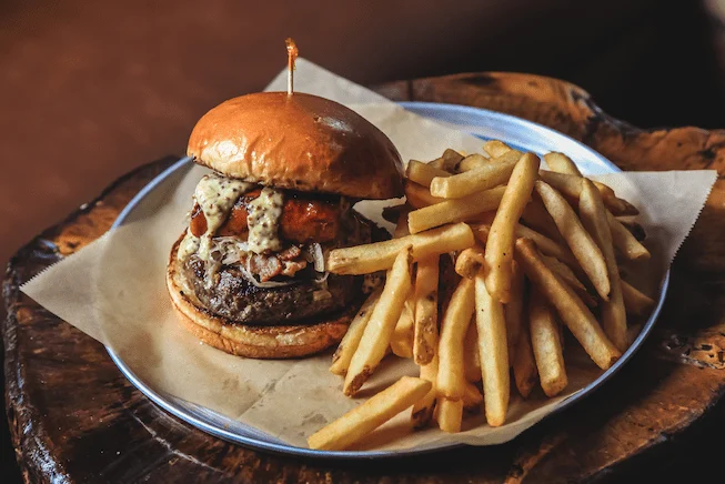 Image of Ceramic plate with a gourmet burgers and fries at Fernwood Inn in Victoria BC